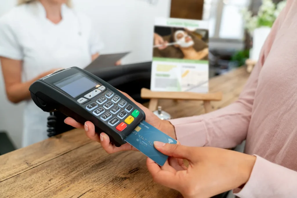 Customer inserting card into terminal at checkout, showing traditional payment systems for businesses.